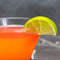 Cocktail with a lime wedge on a dark background