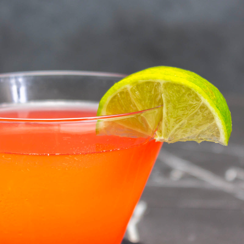 Cocktail with a lime wedge on a dark background