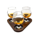 Three sniffer glasses on a stained wooden tray with a white background