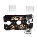 Two champagne flutes with a 'Cheers to the New Year 2026' holder on a white background