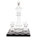 Clear glass chess-piece-shaped decanter with four matching small glasses, displayed on a black-and-white checkered base against a white background.