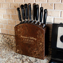 Wooden knife block with engraved names and dates on a kitchen counter.