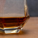 Glass of amber liquid on a wooden surface with a blurred background