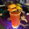 Cocktail with garnishes on a purple coaster