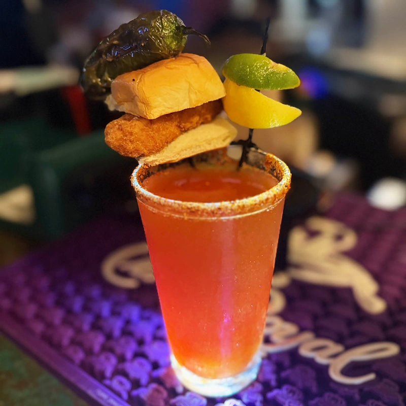 Cocktail with garnishes on a purple coaster