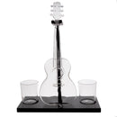 A clear glass acoustic guitar-shaped decanter with a black base, shown on a white background with two small clear glasses on either side of the base.