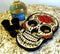 Decorative skull-shaped tray with shot glasses and a bottle of Cabo Wabo tequila on a granite surface.